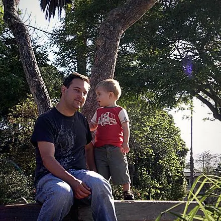 A father and child under a tree.