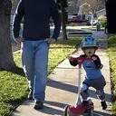 A father and toddler on a suburban street.